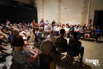 dans une grande pièce, une centaine de personnes assises autour d'un orateur qui parle dans un micro, un rétroprojecteur face à lui - Agrandir l'image 6 sur 9, fenêtre modale