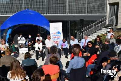 Plusieurs personnes, dont une avec un micro, sont assises les unes face aux autres, un pupitre indiquant "Ville de Gentilly" attend son orateur - Agrandir l'image 3 sur 9, fenêtre modale